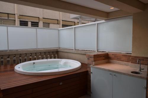 uma casa de banho com uma grande banheira no meio em Giardino Villa Paulista apartaments em São Paulo