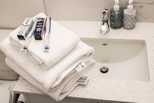 a bathroom counter with towels and a sink at Modern Comfort in Calgary
