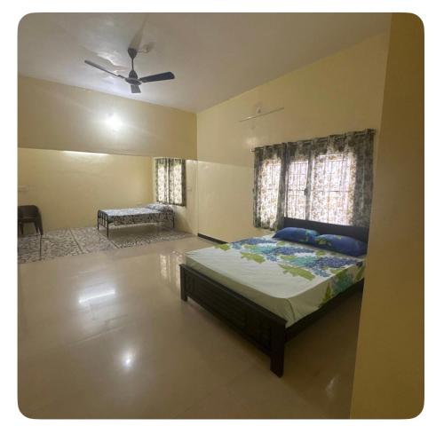 a bedroom with a bed and a ceiling fan at Trichy homestays in Tiruchirappalli