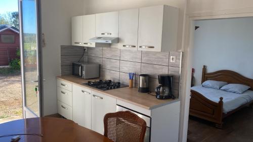 a kitchen with a counter with a stove and a bed at Champvert in Champvert