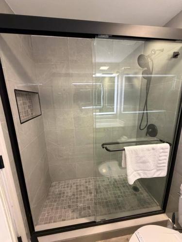 a shower with a glass door in a bathroom at Apartment near the EPIC park in Orlando