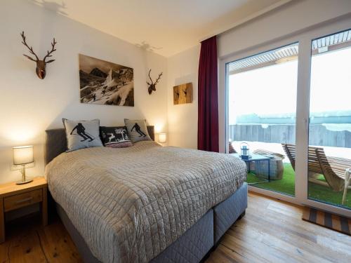 a bedroom with a bed and a large window at Kitzbühel alpine lodge with sauna in Mittersill