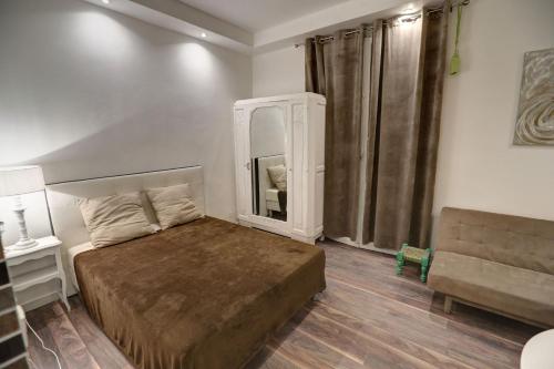 博索萊伊的住宿－Contrast LuxApart 3 min MC Casino，一间卧室配有一张床、一张沙发和一面镜子