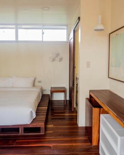 a bedroom with a white bed and a wooden floor at Cote Resort in Dipaculao
