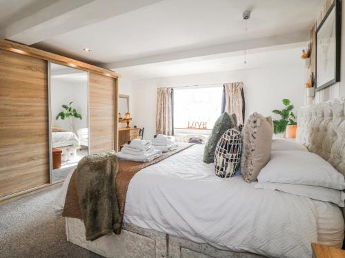 a bedroom with a large bed and a mirror at Fields Farm in Draycott in the Moors