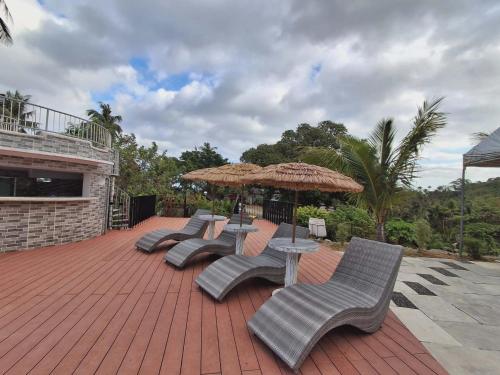 a group of chairs and umbrellas on a patio at May Three Farm in Puerto Galera
