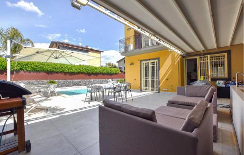 a patio with a couch and a table and a pool at Maison De Paris in San Giovanni la Punta