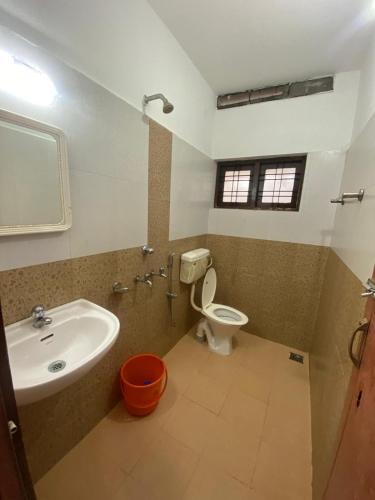 a bathroom with a sink and a toilet and a mirror at Tech City Hotel Trivandrum in Trivandrum