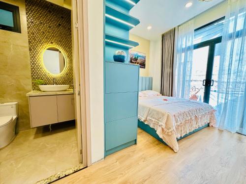 a bedroom with a bed and a bathroom with a sink at Myla House in Ho Chi Minh City