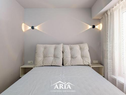 a bedroom with a bed with two lights above it at Fine Boutique Apartment in Chişinău
