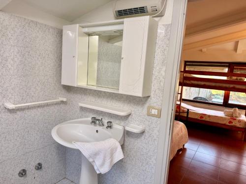 a bathroom with a sink and a mirror and a bed at Casa Barbara in Sant Arcangelo