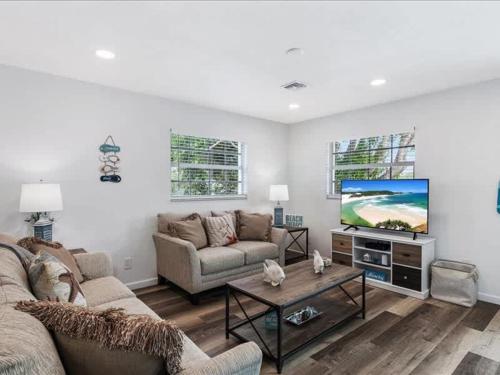 a living room with a couch and a flat screen tv at Beach and Boaters Delight! in Fort Myers Beach