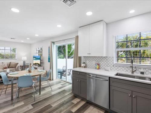 a kitchen with a sink and a table and a kitchen with a living room at Beach and Boaters Delight! in Fort Myers Beach