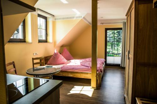 Kleines Zimmer mit einem Bett und einem Tisch in der Unterkunft Gasthaus Rundteil in Bannewitz