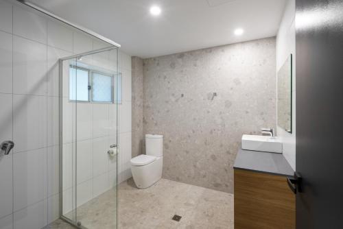 a bathroom with a toilet and a sink and a shower at Settlers Inn in Port Macquarie