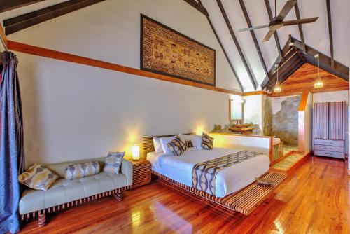 a bedroom with two beds and a couch at Maui Palms in Korolevu