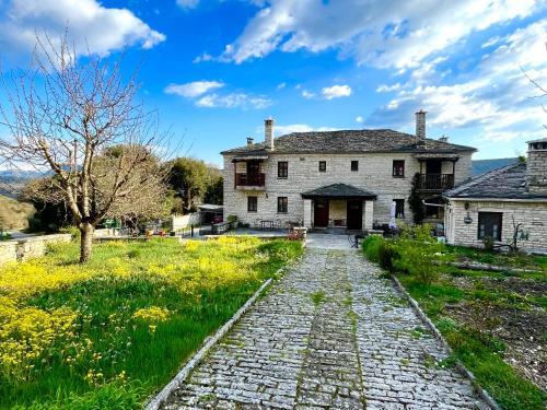 an old house with a cobblestone road in front at Xenonas Achnoulas in Ano Pedina
