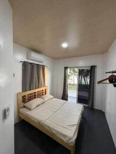 ein Schlafzimmer mit einem Bett und einem großen Fenster in der Unterkunft Zleep Inn in San Juan
