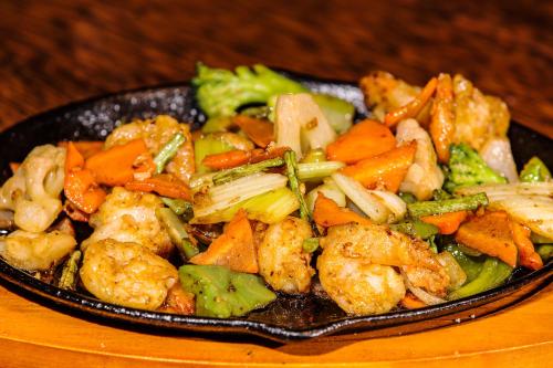 a plate of food with shrimp and vegetables on a table at Maui Palms in Korolevu