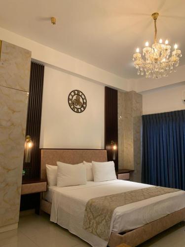 a bedroom with a large bed and a clock on the wall at Azure Luxury Apartment Luxury Stay Near Airport Negombo in Negombo