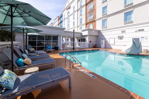 a large swimming pool with chairs and a building at Hampton Inn Lawrenceville Duluth in Lawrenceville
