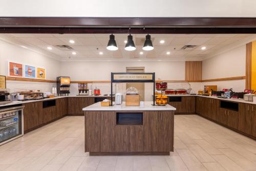 a large kitchen with wooden cabinets and a counter at Hampton Inn Lawrenceville Duluth in Lawrenceville