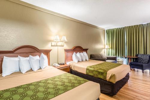 a hotel room with two beds and a chair at Econo Lodge Lake City-North in Lake City