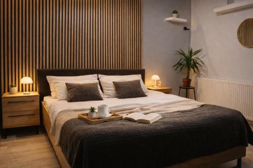 a bedroom with a bed with a tray with two books at Nordic Dream Apartment in Kikinda in Kikinda