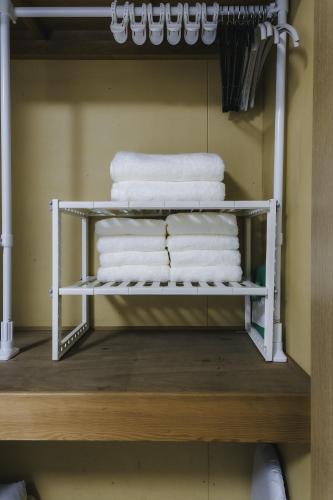 a stack of towels on a shelf in a bathroom at 'Yoyogi House' 10min Walk Shinjuku&Shibuya in Tokyo