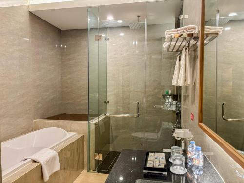 a bathroom with a tub and a glass shower at Cahaya Villa Garut in Garut