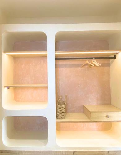 two open shelves in a refrigerator with a box at Zumi Stays in Udaipur