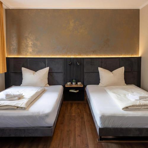 zwei Betten, die in einem Zimmer nebeneinander stehen in der Unterkunft Wali's Hotel in Bielefeld