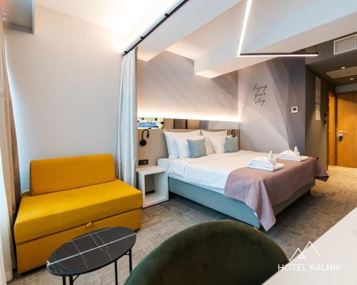 ein Hotelzimmer mit einem Bett und einem Stuhl in der Unterkunft Hotel Kalnik in Križevci