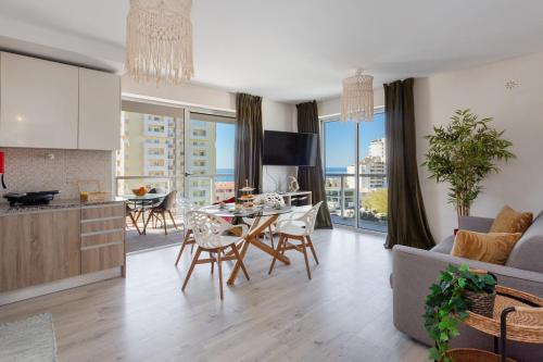 a kitchen and living room with a table and a couch at McRamé Design Apt Sea View, Beachfront, Swimming Pool, 2BDR, 2BAR, 6 pax, Praia da Rocha in Portimão