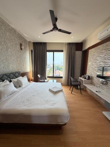 a bedroom with a large bed with a ceiling fan at O'Nest Select in Peth