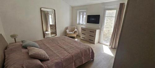 a bedroom with a bed and a television and a chair at Blue Living -Archi di Mare in Marciana Marina