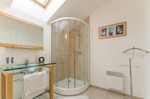 a bathroom with a shower and a glass sink at L'olifred in Mathaux