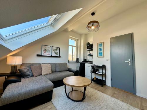 a living room with a couch and a table at Gästeapartment Schkeuditz Dachgeschoss in Schkeuditz