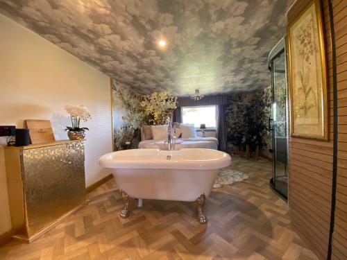 a bathroom with a bath tub and a sink at Simons Whody Hideaway in Ulcombe