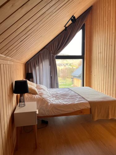 a bedroom with a bed and a window at Mountain View Home in Wysowa-Zdrój