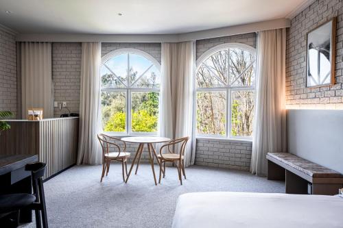 a room with a table and chairs and windows at Trawool Estate in Trawool