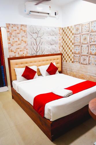 a bedroom with a large bed with red pillows at Sumiwhitehouse in Vallam