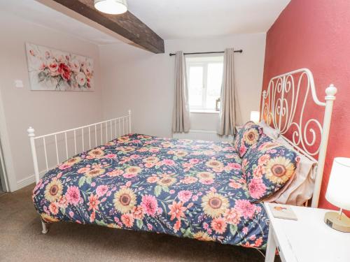 a bedroom with a bed with a floral bedspread at The Granary in Ripon