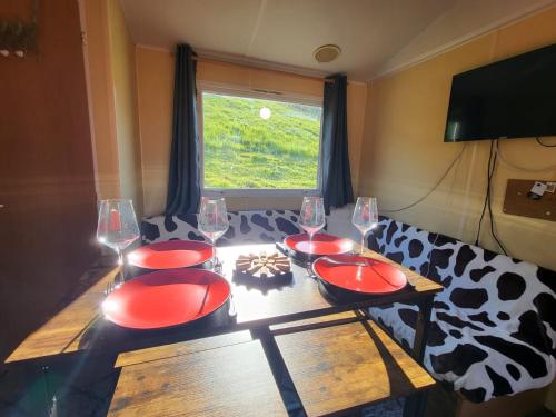 a table with wine glasses and a cow patterned couch at Ti caz prairie in Marnoz