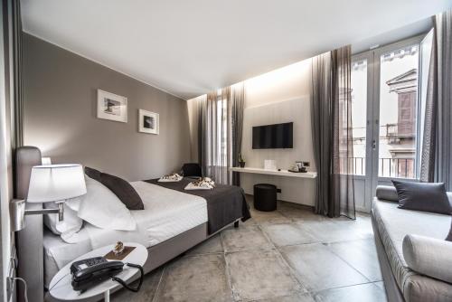 Habitación de hotel con cama y sofá en ETNEA 454 Catania Luxury Rooms, en Catania