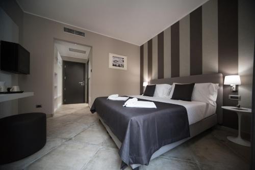 una camera d'albergo con un grande letto e una TV di ETNEA 454 Catania Luxury Rooms a Catania