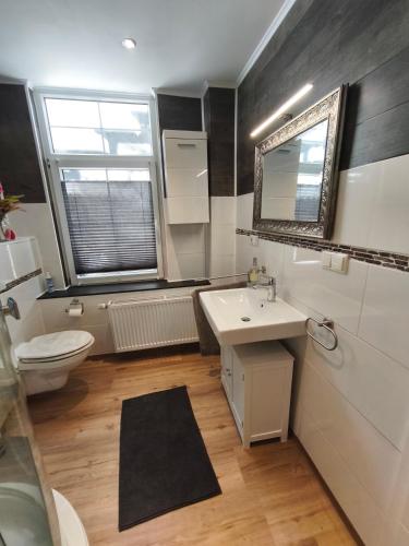 a bathroom with a sink and a toilet and a window at Hehlentor Fachwerkwohnung in Celle