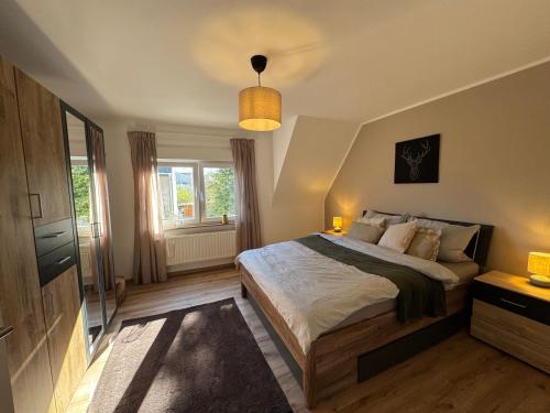 a bedroom with a large bed and a window at Ferienwohnung Eifelhirsch in Ettringen