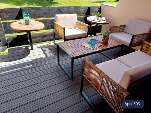 a patio with two chairs and a table and two tables at Fewo Eisvogelnest in Sankt Englmar