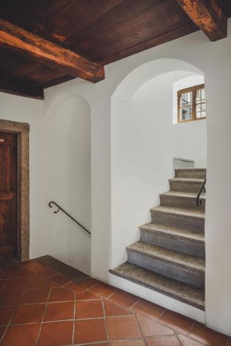 a staircase in a house with wooden ceilings at Ecovillage Sanctuary Bordei in Palagnedra